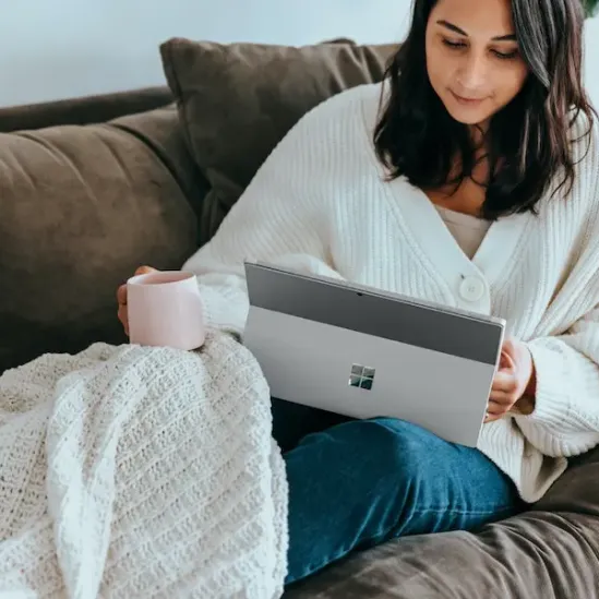 woman using lemon8 app while on the couch