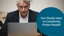 A serious-looking older man sitting at a desk with a laptop, reflecting on the question, 'Do I Really Have to Constantly Praise People?'